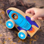 Close up of a childs hand pushing the Lanka Kade plastic-free wooden rocket toy over a rock