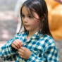 A child wears the LGR Blue Check Classic Button-Up Pyjamas in an outdoor setting.
