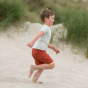 Boy running on some sand wearing the LGR short sleeve blue striped t-shirt