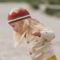 Close up of girl running, wearing a red knitted organic cotton LGR crown