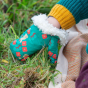 A young child wears the LGR Forest Walk Sherpa Mittens in an outdoor setting.
