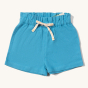 Little Green Radicals Blue Moon By The Sea Twill Shorts. made from GOTS organic Cotton, these beautiful blue shorts have pockets and a white and yellow drawstring cord in the waistband