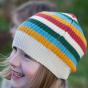 A child wears the LGR Rainbow Striped Beanie Hat outdoors.