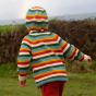 A child plays outdoors wearing the LGR Rainbow Striped Knitted Hooded Cardigan.