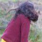 A child wears the LGR From One To Another Berry Snuggly Knitted Jumper in an outdoor setting.