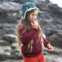 A child wears the LGR From One To Another Berry Snuggly Knitted Jumper in an outdoor setting.