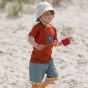 Young boy walking on some sand wearing a red t-shirt and some LGR blue twill shorts