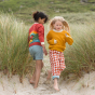 2 girls stood on some sand wearing knitted LGR kids organic cotton cardigans