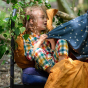 A young child wears the LGR Rainbow Check Classic Button-Up Pyjamas in an outdoor setting.