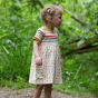 Young girl stood in some woods wearing the organic cotton LGR easy peasy dress 