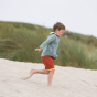 Boy running on some sand wearing an LGR blue twill sherpa collar kids jacket
