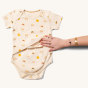 adults hand showing the feeding access on the front of the Little Green Radicals Adaptive Easy Feeding Sunshine & Rainbows Bodysuit