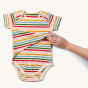 Adults hand showing the easy feeding access on the front of the Little Green Rainbows Adaptive Easy Feeding Rainbow Striped Bodysuit
