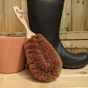 LoofCo Gardener's coconut coir garden Brush pictured placed in front of a black wellington boot and terracotta garden pot 