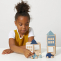 Girl playing with the plastic free handmade lubulona winterburg town set on a white table