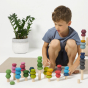Child crouched down playing with the Lubulona waldorf stacking tree blocks on a white floor