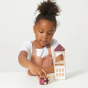 Girl playing with the Lubulona plastic free wooden mini autumn vale doll town on a white table