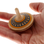 Mader Arabesk Finger Spinning Top sits in an adult hand against a plain background.