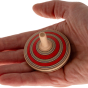 Mader Fado Maple Spinning Top sits in an adult hand against a plain background.