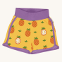 Maxomorra Children's Organic Cotton Pineapple Runner Shorts. A bright, yellow fabric with whole and half pineapple print, purple piping along the sides and bottom of the shorts, and a thick purple wasteband