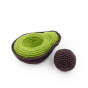 Myum crochet avocado seed next to a cotton avocado toy on a white background