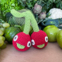 Myum eco-friendly cherry sister soft toys in front of some real green apples on a wooden table