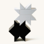 Naef black and white premium wooden toy blocks stacked in 2 star shapes on a beige background