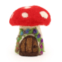 A closer view of the details on The Makerss Needle Felt Toadstool House. A beautifully crafted Fly Agaric Toadstool Fairy house with a red and white spotted top, cream base and a brown door adorned with purple and blue flowers, stood on a white