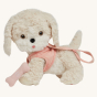 The Olli Ella Dinkum Dog "Cookie" is a dog shaped stuffed toy with soft cream coloured fur, a pale pink harness and lead, and soft brown eyes and a bone. 