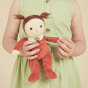 Close up of young girl holding an olli ella red dinky dinkum doll toy
