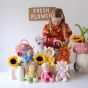 A child has set up a flower stall with fresh flowers and the full range of Olli Ella Dinky Dinkum Blossom Buds  