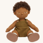 Olli Ella Button poseable, soft bodied, curly haired, Dinkum Doll sitting down pictured on a plain coloured background 