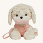 The Olli Ella Dinkum Dog "Cookie" is a dog shaped stuffed toy with soft cream coloured fur, a pale pink harness and lead, and soft brown eyes and a bone in its mouth.