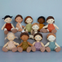 A group of 10 different Olli Ella Dinkum Dolls. They are all sat down and pictured against a blue background 