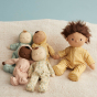 4 Olli Ella daydream collection dozy dinkum dolls laying on a white blanket next to a dinkum doll wearing the goldie pyjamas