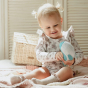 Olli Ella Holdie Folk Ocean Animals whale toy, held by a toddler in floral bodysuit, olli Ella basket behind with wooden shutters, sat on knitted blanket 