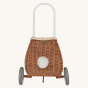 The back view of the Olli Ella Rattan Bunny Luggy with Lining – Gumdrop. A beautifully woven Luggy roll along basket with a light peach lining and gum drop detail, with a fluffy bunny tail, on a cream background.