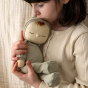 Close up of a girl cuddling an Olli Ella soft cotton Dozy Dinkum baby doll in front of a cream background