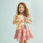 Young girl holding the goldie pip and moppet ocean dozy dinkum dolls on a blue background