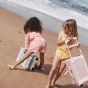 Children playing on a beach both are holding an Olli Ella See-Ya Suitcase 