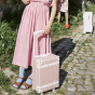 child holding an Olli Ella Pink Daisies See-Ya Suitcase 