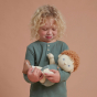 A child cradling pea the Dinkum Doll in their arms 