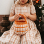 child holding basket placing a sweet inside