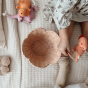 The Olli Ella Rattan Lily Basket Set in Seashell Pink view from above, next to a child surrounded by toys.