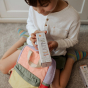 A child opens the Olli Ella Playpa Children's Colouring Paper Roll Travel Pack in a home environment.