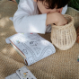 A child looks for the perfect colour to use with the Olli Ella Playpa Children's Colouring Paper Roll Travel Pack  -  Fairytale Design in an outdoor setting.