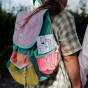 A child carries the Olli Ella Playpa Children's Colouring Paper Roll Travel Pack  -  Forest Design and fairytale Design in her backpack pocket whilst outdoors.