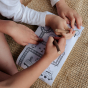 Two children play with the Olli Ella Playpa Children's Colouring Paper Roll Travel Pack  -  Forest Design in a home setting.