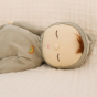 Close up of the Olli Ella Pickle Dozy Dinkum doll sleeping on a cream bed 
