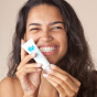 Person holding a tube of OY! Clear Skin Purifying Serum smiling 